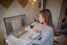 A young woman uses a computer to research the best online degrees to fit her life.