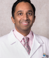 Online bioethics master's instructor Dr. Ashley Fernandes smiles in his professional headshot.