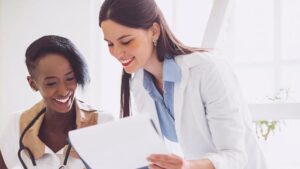 Medical professionals collaborating while reviewing digital records.