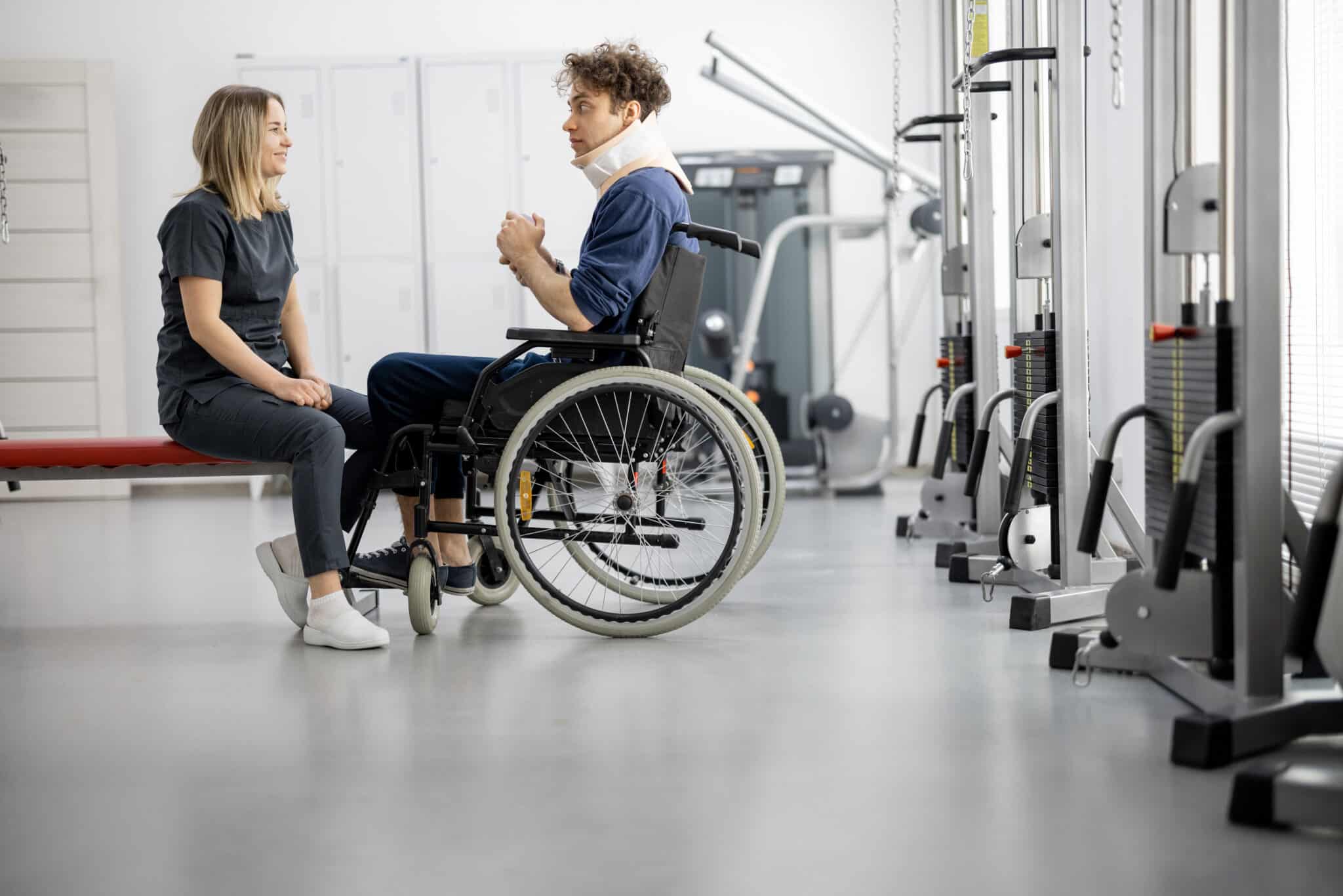 health care worker in gym with man in a wheelchair