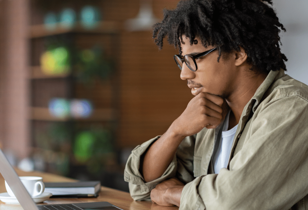 A student sits at a desk with a laptop