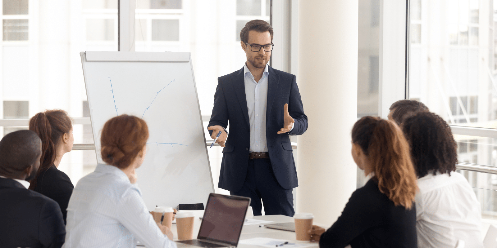 A businessperson presents to a group of colleagues.