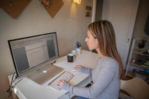 A young woman uses a computer to research the best online degrees to fit her life.