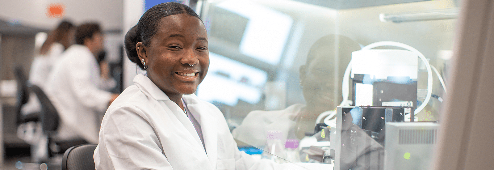 Student in a white coat in a lab