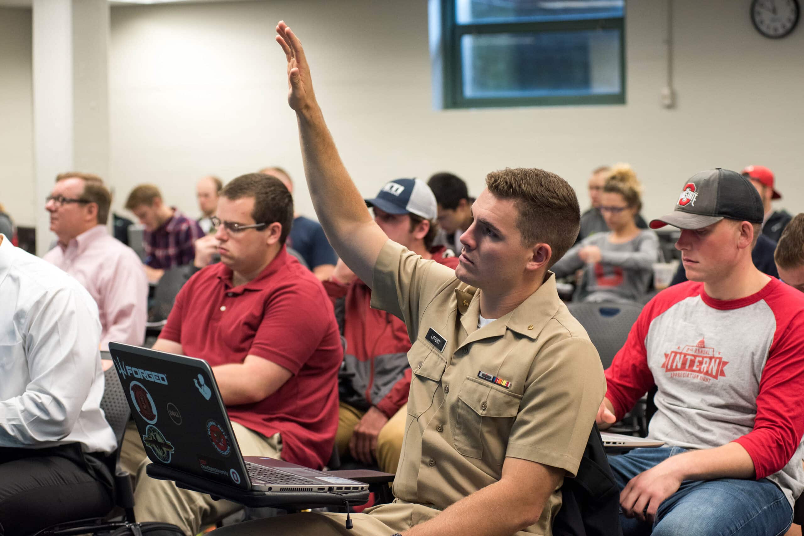 Military student raises hand in class.