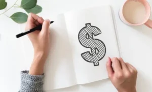 Writing in a white pad with a dollar sign