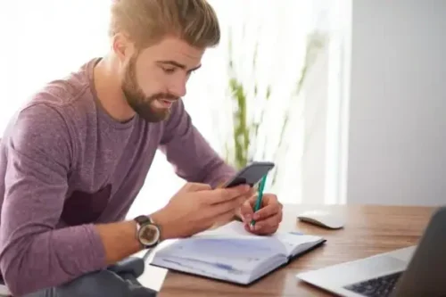 student working in planner with a phone