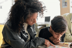 An applied behavior analysis professional reads a book with a child.