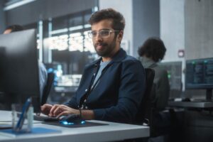Male cybersecurity professional working on a desktop in an office.