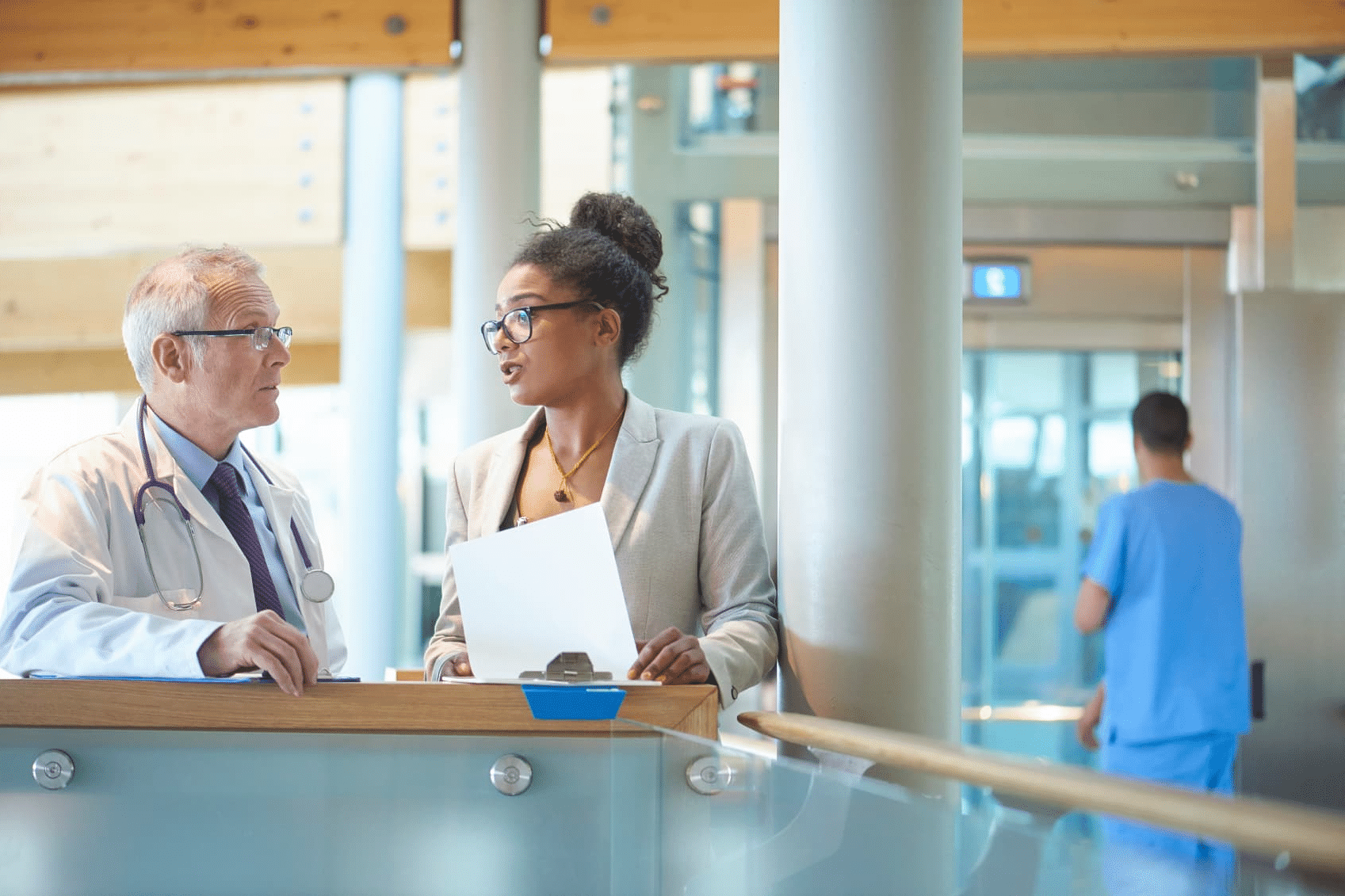 Health administrator and medical professional conversing.